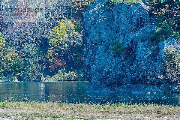 Felswände mit herbstlichen Bäumen  die sich in einem ruhigen See spiegeln und eine friedliche Landschaft schaffen  in Südkorea