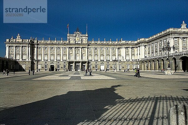 Ein majestätischer Palast an einem sonnigen Tag  Menschen spazieren auf dem weitläufigen Vorplatz Madrid Spanien