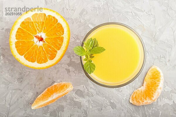 Glas Orangensaft auf einem grauen Hintergrund aus Beton. Morninig  Frühling  gesundes Getränk Konzept. Draufsicht  Nahaufnahme  flach legen