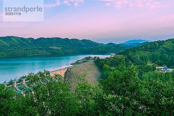 Blick auf einen Staudamm an einem See  umgeben von Bergen  in der Abenddämmerung  in Südkorea