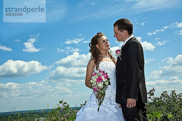 Hochzeitspaar stehen im Gras in sonnigen Sommertag