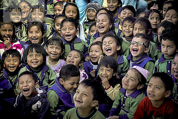 Kinder von Marktarbeitern in einer Kindertagesstätte schauen voller Freude einem Zauberer  einem Clown und ethnischen Tänzern zu; Quito  Ecuador