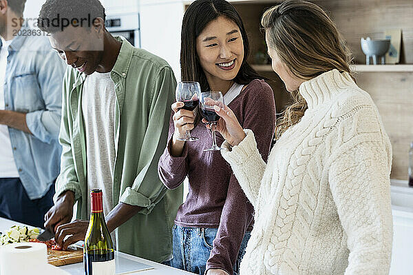 Zwei Freunde stoßen während eines Freundestreffens mit Weingläsern an