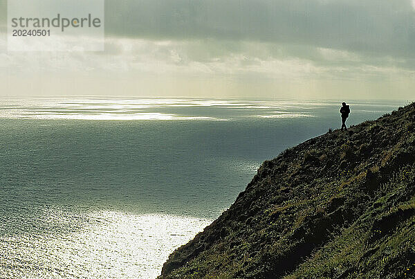 Silhouette einer Figur auf einer Küstenklippe von St. Paul Island; St. Paul Island  Pribilof Islands  Alaska  Vereinigte Staaten von Amerika