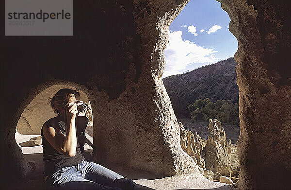 Frau fotografiert alte indische Klippenwohnungen; New Mexico  Vereinigte Staaten von Amerika