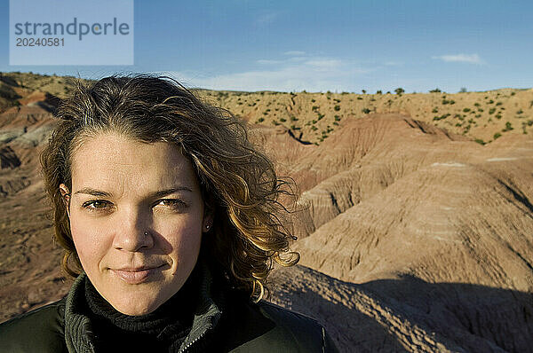 Außenporträt einer jungen Frau mit lockigem Haar  die auf einem Felsvorsprung auf der Ghost Ranch in der Nähe von Santa Fe posiert; New Mexico  Vereinigte Staaten von Amerika