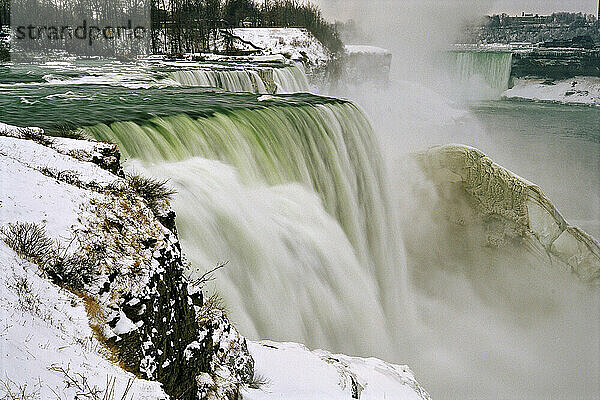 Winteransicht der kaskadierenden Niagarafälle  wo Nebel und Gischt eine Eiskruste bilden  die sich im eiskalten Wasser bildet; Niagarafälle  New York  Vereinigte Staaten von Amerika