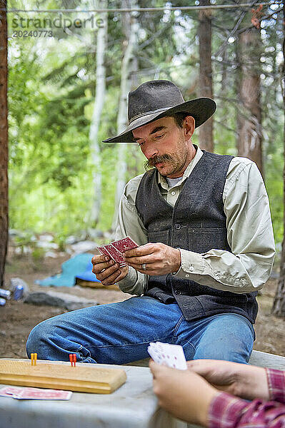 Cowboy spielt Karten beim Camping im Kings National Park  Kalifornien; Kalifornien  Vereinigte Staaten von Amerika