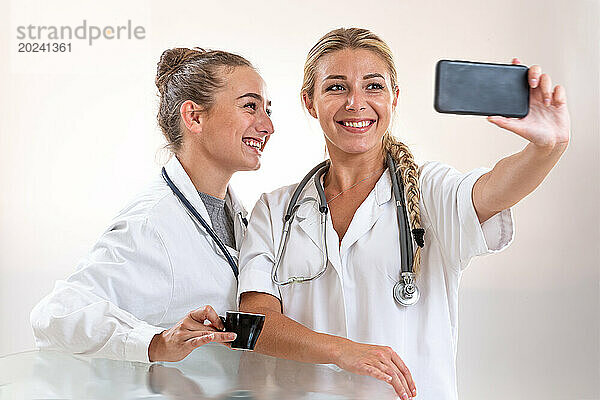 Zwei Kollegen machen in der Kaffeepause ein Selfie.