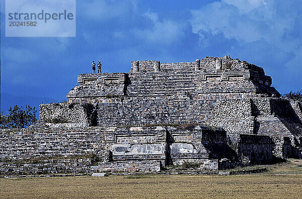 Touristen stehen auf den Ruinen von Monte Alban  einer Hauptstadt der Zapoteken. Es handelt sich um eine große präkolumbianische archäologische Stätte mit Pyramiden und Terrassen im mexikanischen Bundesstaat Oaxaca. Monte Alban  Oaxaca  Mexiko