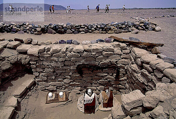 Skelette bleichen in der Wüstensonne Chauchilla-Friedhof  eine Grabstätte aus der späten Nazca-Zeit von 500–700 n. Chr. Grabräuber haben die meisten Gräber an diesem abgelegenen Ort im Süden Perus geplündert und Knochen  Kleidungsstücke und Tonscherben im glühenden Sand verstreut. Touristen zahlen dafür  einige Schädel zu sehen  die neu arrangiert wurden. Mumien mit Haaren  Zähnen und Kleidung liegen in felsenummauerten  nach Osten ausgerichteten  grabähnlichen Gräbern; Peru