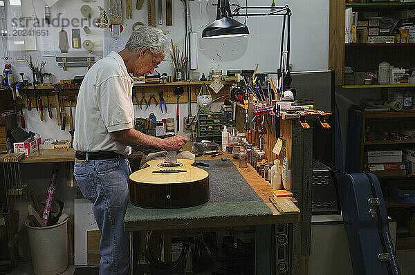 Gitarrist arbeitet in seinem Laden an einer Gitarre