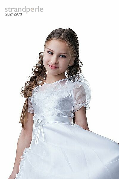 Kleine Schönheit Kind posiert in weißem Kleid vor weißem Hintergrund