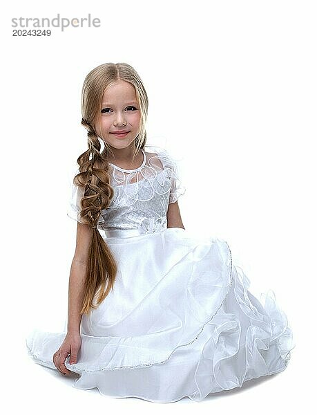 Kleine blonde Schönheit Kind sitzen weißes Kleid vor weißem Hintergrund