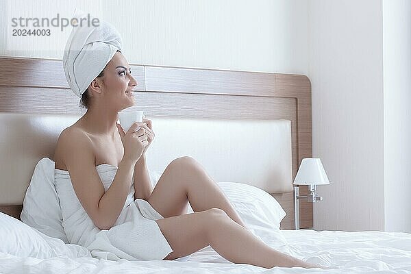 Schöne Brünette Frau trägt nur Handtücher auf ihrem Körper und Kopf