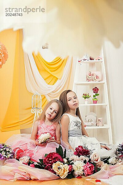 Studioaufnahme von hübschen Schwestern  die mit Blumen posieren  Nahaufnahme
