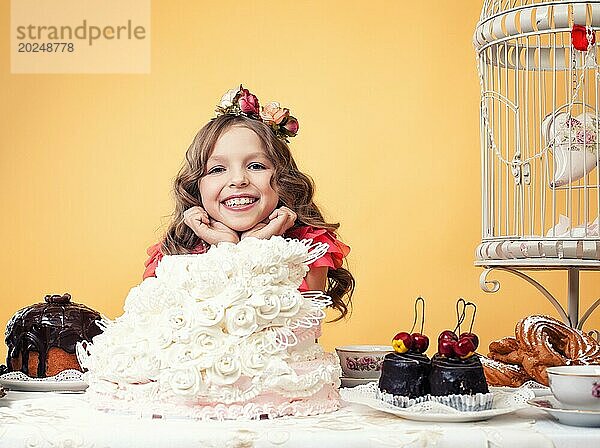 Bild von glücklichen lächelnden Mädchen posiert mit vielen Süßigkeiten