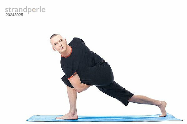 Attraktiver Mann in schwieriger Yoga Position  vor weißem Hintergrund