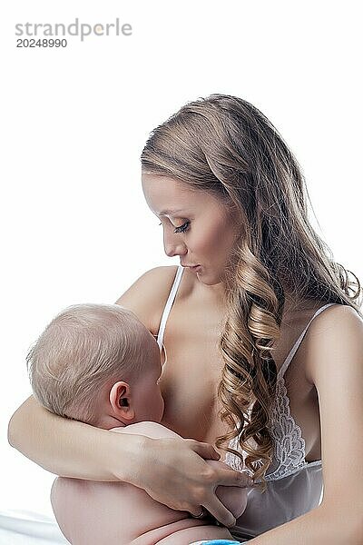 Studioaufnahme einer glücklichen Mutter  die ihr Baby stillt