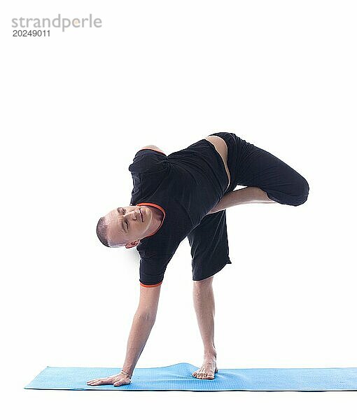 Studioaufnahme eines muskulösen Mannes beim Yoga  vor weißem Hintergrund