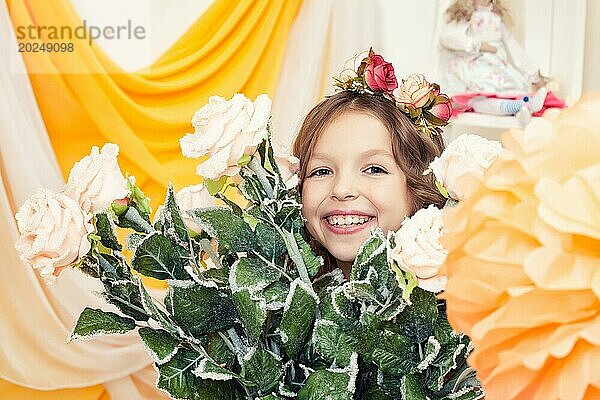 Glückliches kleines Mädchen posiert mit großem Rosenstrauß  Nahaufnahme