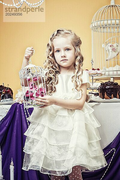 Intelligentes kleines Mädchen posiert in einem gemütlich eingerichteten Studio  Nahaufnahme