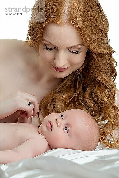 Bild einer hübschen rothaarigen Mutter  die sich um ihr Baby kümmert
