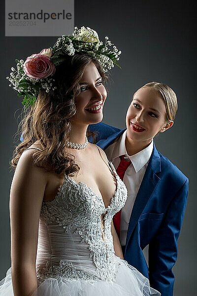 Lesbische Hochzeit. Glückliche Braut und Bräutigam posieren im Studio