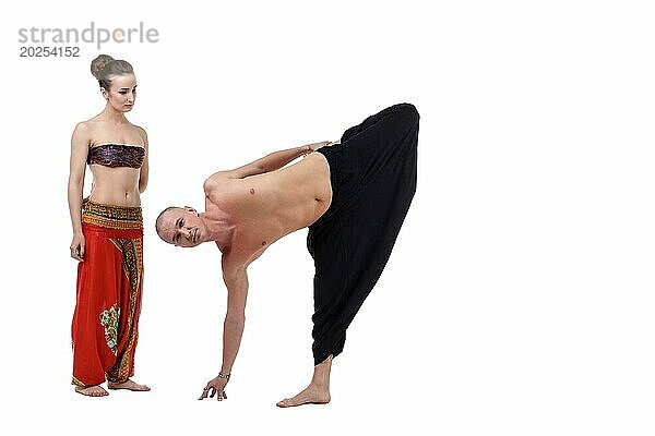 Frau sieht zu  wie der Yogalehrer eine Asana ausführt. Studioaufnahme  vor weißem Hintergrund