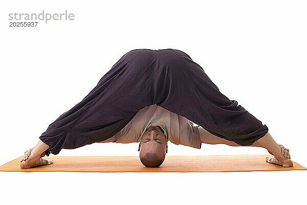 Entspannter Mann in schwieriger Yoga Pose  vor weißem Hintergrund
