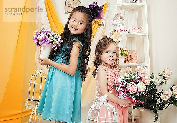 Zwei süße Freundinnen posieren mit Blumensträußen