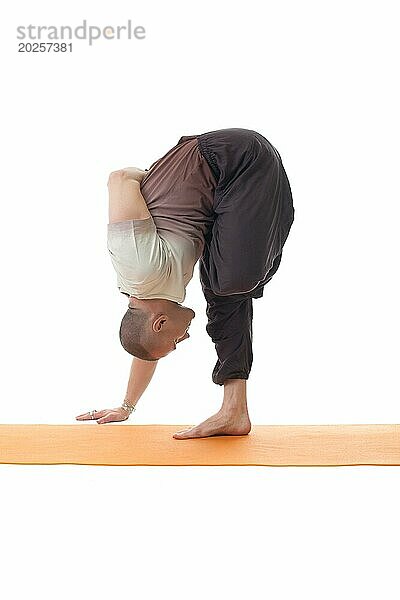 Seitenansicht eines flexiblen Mannes in Yoga Pose  vor weißem Hintergrund