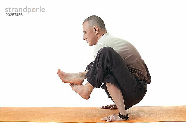 Bild von Yoga Lehrer posiert in schwierigen Asana  vor weißem Hintergrund