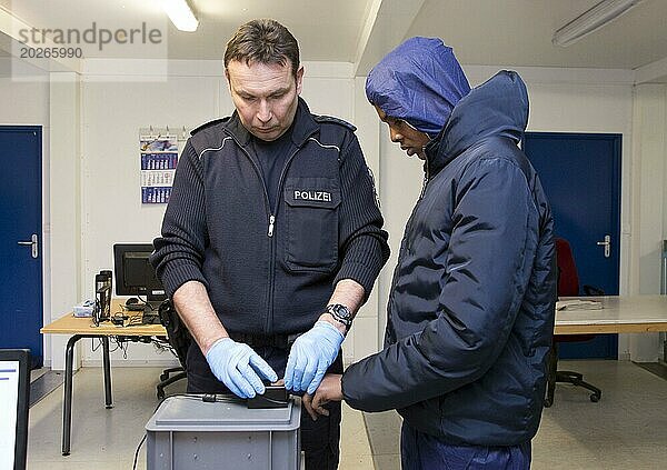 Flüchtlinge werden bei der Bundespolizei in Rosenheim registriert und erfasst. Ein Polizist der Bundespolizei macht einen Fingerabdruck Scan  05.02.16