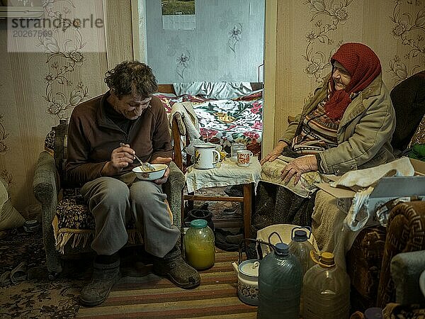 Varvara  85 Jahre und ihr Sohn Leonid  56 Jahre. Leonid kümmert sich um seine pflegebedürftige Mutter. Sie selbst  Leonid und sein Bruder leben von der geringen Rente der alten Frau. In Borshchiwka überleben die Menschen nur durch humanitäre Hilfe  die Front ist nur einige Kilometer Luftlinie entfernt  Borshchiwka  Raion Isjum  Oblast Charkiw  Ukraine  Europa