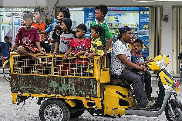 Kinder auf einem Fahrzeug in einem indonesischen Dorf  dörflich  Kind  Junge  neugierig  Neugier  Kindheit  unbeschwert  Lebensstil  Dorfleben  Straßenszene  asiatisch  Authentisch  Einheimische  Tradition  traditionell  Reise  Tourismus  Kultur  Armut  Person  Lombok  Indonesien  Asien