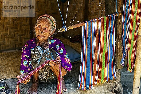 Alte Frau bietet Textilien zum Verkauf an  Textil  Alter  Mensch  Arbeit  bunt  Kleidung  dörflich  anbieten  verkaufen  Frau  Handel  Basar  Authentisch  Stoff  Stoffmuster  Handwerk  Handarbeit  asiatisch  Einheimische  Tradition  traditionell  Marktplatz  Reise  Tourismus  Kultur  Armut  Präsentation  Lebensstil  Person  Muslim  Islam  Sasak  Indigene  Ureinwohner  Kulturerbe  Seidenweberei  Portrait  Mensch  Dorf Sade  Lombok  Indonesien  Asien