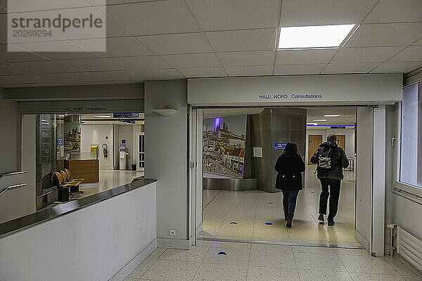 2 Personen gehen von hinten durch einen Korridor der Nordhalle eines Krankenhauszentrums.