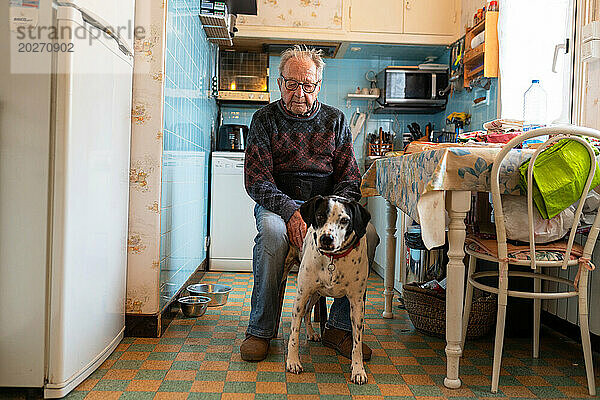 Einsamkeit älterer Menschen  Senioren  die allein mit ihrem Hund in der Küche leben.