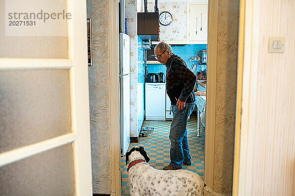 Einsamkeit älterer Menschen  Senioren  die allein mit ihrem Hund vor der Kühlschranktür leben.