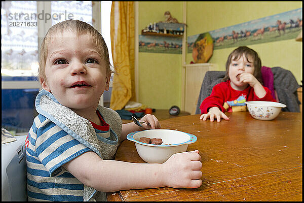 ASE – Sozialhilfe für Kinder. Maxence  2 Jahre alt  und seine Schwester Sarah  3 Jahre alt  frühstücken am Tisch. NUR FÜR REDAKTIONELLE ZWECKE.