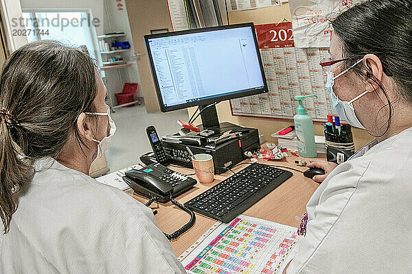 2 Krankenschwestern besprechen Patienten im Büro der Entbindungsstation.