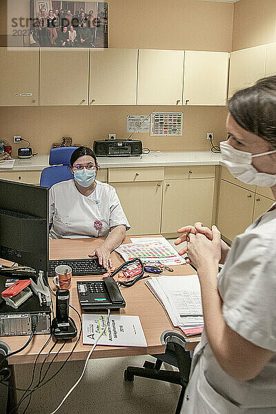 2 Krankenschwestern besprechen Patienten im Büro der Entbindungsstation.