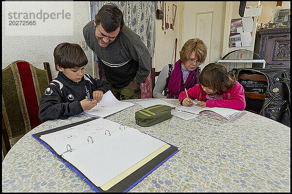 ASE – Sozialhilfe für Kinder. Nicolas und Oceane machen ihre Hausaufgaben mit der Hilfe von Isabelle und ihrem Vater. NUR FÜR REDAKTIONELLE ZWECKE.