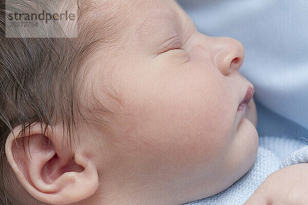 Schläfriges Neugeborenengesicht. Baby ist 2 Tage alt.