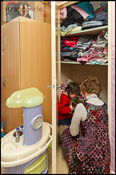 ASE – Sozialhilfe für Kinder. Isabelle wählt mit Sarah Kleidung aus einem Kleiderschrank in ihrem Schlafzimmer aus. NUR FÜR REDAKTIONELLE ZWECKE.