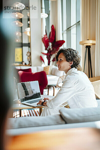 Geschäftsfrau sitzt mit Laptop in der Hotellobby