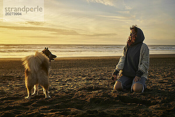 Junge Frau mit Hund am Strand