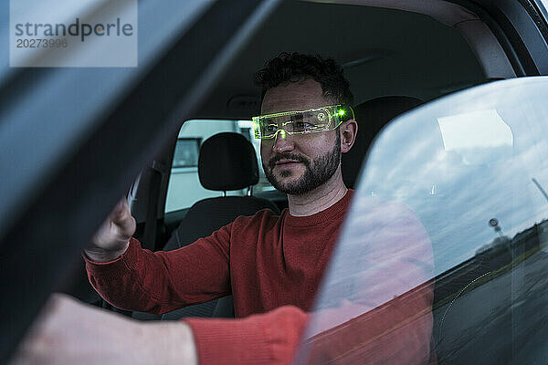 Mann trägt intelligente Brille und sitzt im Auto