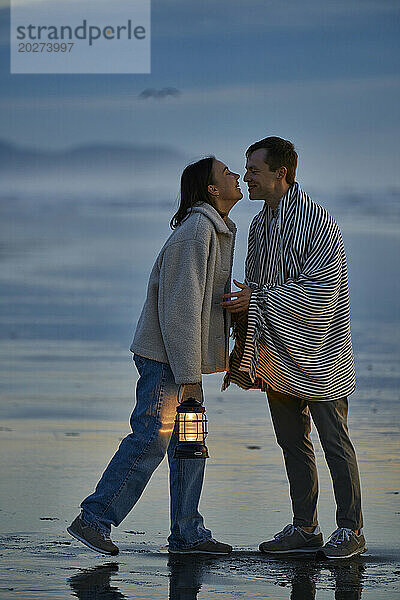 Liebevolles junges Paar verbringt seine Freizeit am Meeresstrand